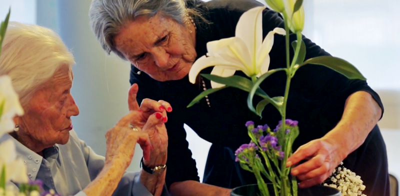 Mujeres mayores cuidan de unas flores
