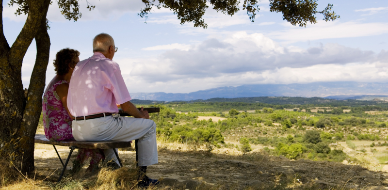 Pareja mayor sentados de espaldas contemplando el paisaje