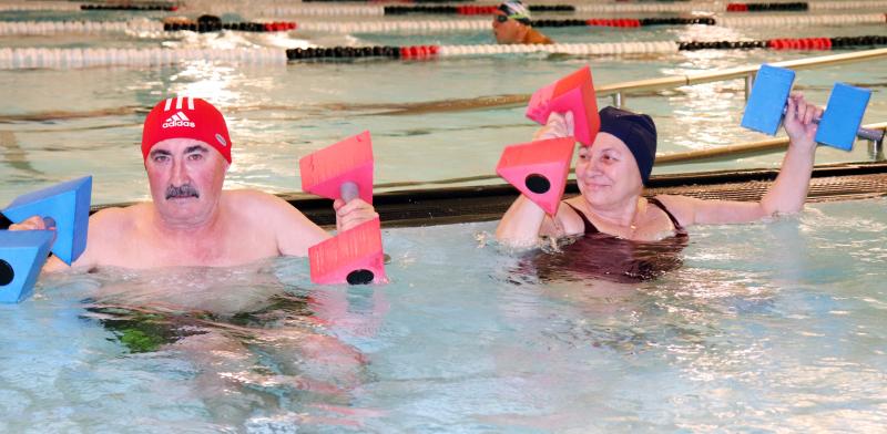 Personas haciendo ejercicio en una piscina cubierta