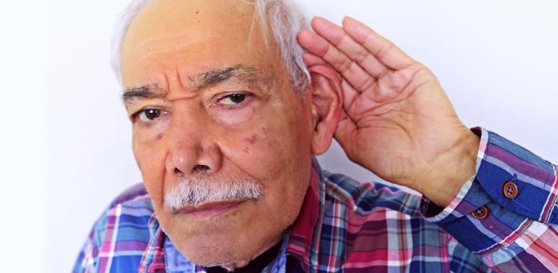 Persona llevándose una mano al oído en un gesto de que no oye bien