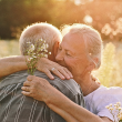 Pareja de personas mayores dándose un abrazo en pleno naturaleza